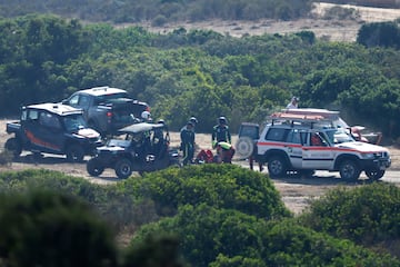 Los sanitarios atienden a Carlos Sainz tras salir del coche por su propio pie. 