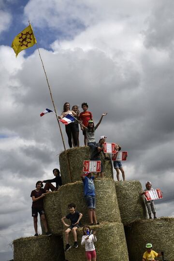 Jóvenes aficionados del Tour animan con las banderas de sus favoritos.