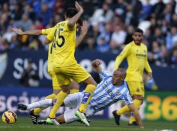 Nordin Amrabat cae ante los jugadores del Villarreal el defensa Víctor Ruiz y el centrocampista Manuel Trigueros.