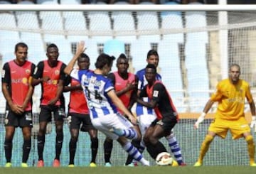 El jugador de la Real Sociedad Rubén Pardo (c) lanza una falta contra la barrera del U.D. Almería.