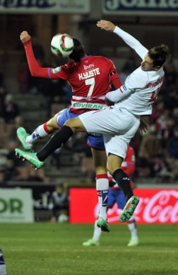 El centrocampista polaco del Sevilla Grzegorz Krychowiak (d) disputa un balón aéreo con el centrocampista de Granada Héctor Yuste (i), durante el partido de octavos de final de la Copa del Rey que se juega hoy en el estadio Los Cármenes, de Granada.