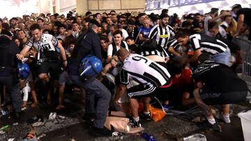 Varios aficionados intentan rescatar a los heridos en la estampida que se produjo en la Piazza San Carlo de Turín durante la final de la Champions entre el Real Madrid y la Juventus de Turín.