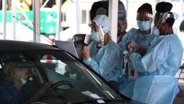 Health care workers direct a person to use a nasal swab for a self administered test at the new federally funded Covid-19 testing site at the Miami-Dade County Auditorium on July 23, 2020 in Miami, Florida.