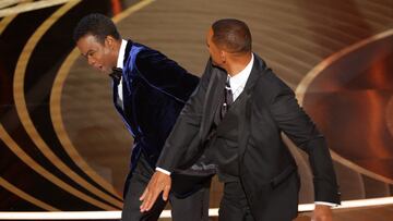 Will Smith (R) hits Chris Rock as Rock spoke on stage during the 94th Academy Awards in Hollywood, Los Angeles, California, U.S., March 27, 2022. REUTERS/Brian Snyder