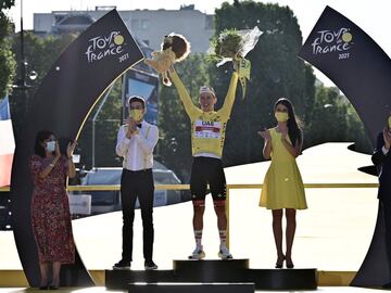 El ganador del equipo UAE Emirates, Tadej Pogacar de Eslovenia, celebra su maillot amarillo de líder general en el podio junto a la alcaldesa de París Anne Hidalgo