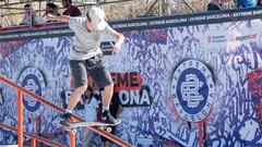 El skater Yakov Terrell de Boardslide en el rail de la Street Plaza del Extreme Barcelona, el 26 de septiembre del 2021 en el Parc del F&ograve;rum, con un mural del evento detr&aacute;s. 