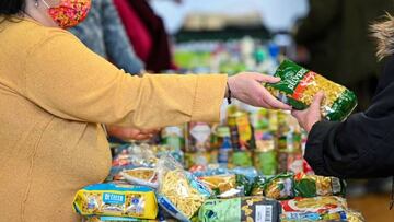 A volunteer hands a package of pasta to a customer at a food bank of the 'Seniorenglueck' association during in Dortmund, western Germany, on January 19, 2023. - The 'Seniorenglueck' association provides senior citizens with food and hygiene articles and runs a food distribution for needy people once a month. The association has set itself the task of helping people, especially the elderly, who are dependent on help due to their social situation. (Photo by Ina FASSBENDER / AFP) (Photo by INA FASSBENDER/AFP via Getty Images)