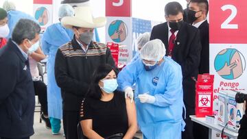 Peru's President Pedro Castillo observers a teacher as she receives a dose of the Sinopharm vaccine against the coronavirus disease (COVID-19) during the launch of a mass immunisation rollout for teachers in Lima, Peru, September 3, 2021. REUTERS/Sebastian Castaneda