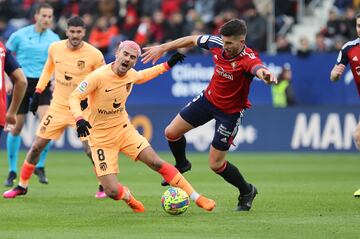 El delantero francés del Atlético de Madrid, Antoine Griezmann, lucha por el balón con el defensor español de Osasuna, David García,