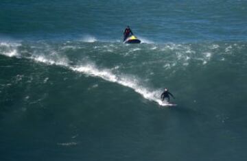 Justine Dupont keeping low as he drops in. In January 2013 Garrett McNamara successfully rode what was estimated to be the first 100 ft wave at Nazaré.