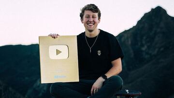 Josh Neuman, experot en longboard downhill, posa en lo alto de la montaña sentado en un monopatín con la insignia de oro de YouTube por haber alcanzado el millón de suscriptores en la red social de vídeos por excelencia.