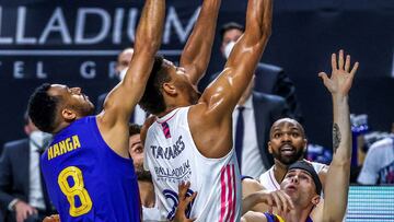 GRAF3583. MADRID, 11/03/2021.- El pívot caboverdiano del Real Madrid Walter Tavares (c) lanza a canasta ante los jugadores del Barcelona Adam Hanga (i) y Kyle Kuric durante el partido de Euroliga que se disputa este jueves en el Wizink Center. EFE/JuanJo Martín