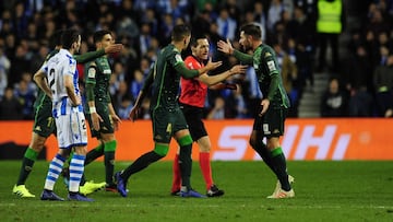 Los jugadores del Betis rodean a Prieto Iglesias.