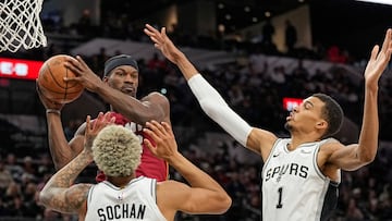 Miami Heat forward Jimmy Butler (22) looks to pass the ball while defended by San Antonio Spurs forwards Victor Wembanyama (1) and Jeremy Sochan (10) at Frost Bank Center.
