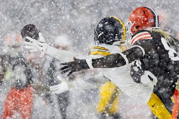 Beanie Bishop Jr. de los Pittsburgh Steelers, y David Njoku Cleveland Browns. Tratan de agarrar el bal¨®n bajo la nieve.