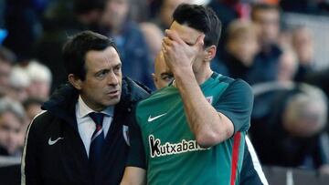 El delantero del Athletic Club Aritz Aduriz (d), junto al entrenador Ernesto Valverde, se retira del campo lesionado durante el partido correspondiente a la 23 jornada de Liga contra el Valencia esta tarde en el estadio de Mestalla.