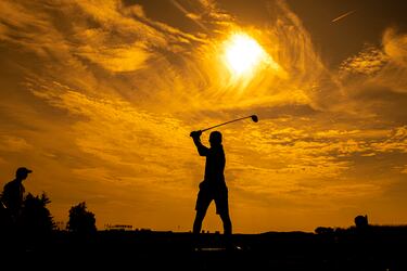 Jugando al golf en la puesta de sol