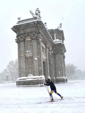 Un esquiador pasa por delante de la Puerta de Alcalá. 