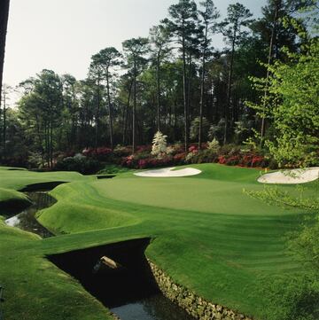 Entrar en Amen Corner, los hoyos 11, 12 y 13 del Augusta National, es entrar en uno de los sacrosantos lugares del golf. Nombrado así por Herbert Warren Wind, periodista de Sports Illustrated, en honor al disco de jazz 'Shouting at Amen Corner', es un sueño para el primerizo en Augusta que se puede tornar en pesadilla en cualquier momento. Arranca en el par 4 llamado 'White Dogwood', calle estrecha y cuesta arriba y un green protegido por un lago a la izquierda y un búnker en la parte trasera. Luego viene 'Golden Bell', uno de los par 3 más famosos del mundo y el hoyo más corto del campo. A merced del viento, los jugadores tienen que sortear Rae's Creek, el arroyo que pasa enfrente del green, y los tres búnkers que lo custodian. Muchos se han derretido ahí antes de llegar a 'Azalea'. Flanqueado por unas 1.600 plantas de esta especie, este par 5 que cierra Amen Corner, que se alargó el año pasado, es el origen del nombre de la hija de Sergio García y una trampa con otro arroyo y cuatro búnkers dificultando la llegada a green. No siempre es decisiva, pero esta endiablada sucesión de hoyos ha fabricado más de un triunfo y más de un fracaso.
