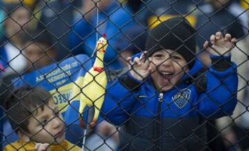 Dos niños alientan a Boca Juniors en el Superclásico.