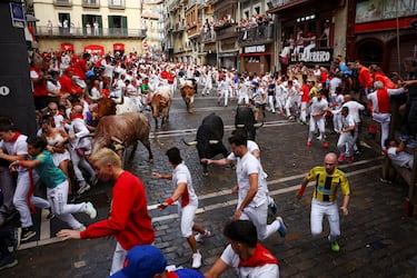 Participantes corren delante de los toros durante el primer encierro de los Sanfermines en Pamplona.