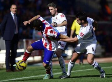 Arda Turan disputa la pelota con Jose Rodriguez y Pablo Insua durante el partido de la decimotercera jornada de Liga de Primera División disputado en el estadio Vicente Calderón de Madrid.