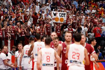 Mientras los aficionados letones celebran el triunfo de la Selección báltica, los jugadores de ambas escuadras chocan las manos.