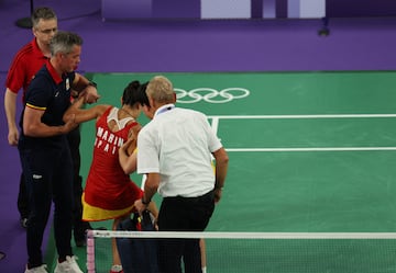 Carolina Marín se levanta con la ayuda de su entrenador.