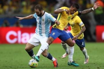 BELO HORIZONTE, BRAZIL - NOVEMBER 10: Paulinho (R) of Brazil struggles for the ball with Gonzalo Higuain of Argentina during a match between Brazil and Argentina as part of 2018 FIFA World Cup Russia Qualifier at Mineirao stadium on November 10, 2016 in B