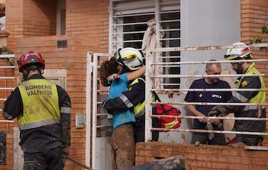 Una mujer abraza a una trabajadora de los servicios de emergencia tras las inundaciones en Massanassa, en las afueras de Valencia.