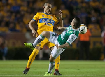Jorge Torres (L) of Tigres vies for the ball with Sebastian Ramos (R) of Leon during their Mexican Apertura 2017 tournament football match at the Universitario stadium in Monterrey, Mexico on November 25, 2017. / AFP PHOTO / Julio Cesar AGUILAR