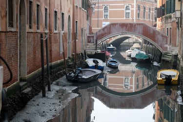 Los barcos se muestran en un canal durante una marea baja severa en la ciudad laguna de Venecia, Italia.