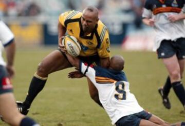 Jonah Lomu que lucha por el balón con George Gregan durante el partido que enfrentó a los Brumbies y los Hurricanes.