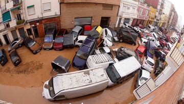 Fotografía de vehículos amontonados luego de ser arrastrados por las inundaciones en Valencia, España.