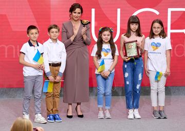 La presidenta de la Comunidad de Madrid, Isabel Díaz Ayuso, entrega uno de los galardones a los niños ucranianos escolarizados en colegios de la Comunidad de Madrid representados por Anna, Snifana, Yevlen, David, Ruslan y Sofía.