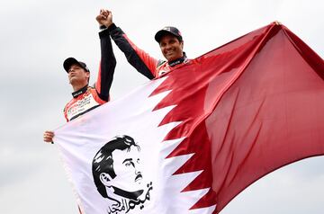 Nasser Al-Attiyah y su copiloto Mathieu Baumel celebrando el segundo puesto en la categoría de coches