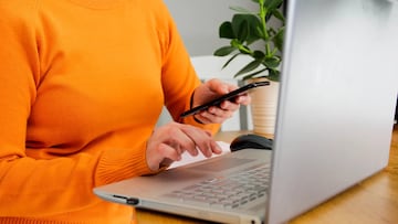 Mujer usando el PC y el m¨®vil a punto de ser estafada.