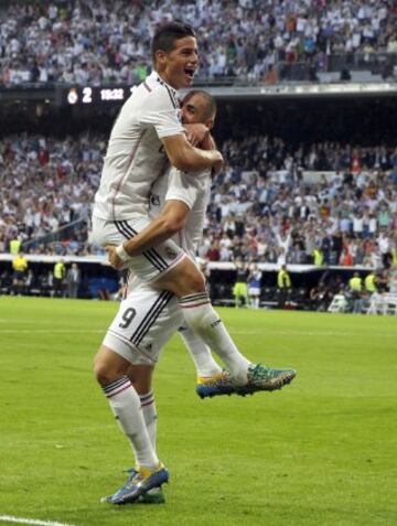 El delantero francés del Real Madrid Karim Benzema (d) celebra con su compañero, el centrocampista colombiano James Rodríguez, el gol marcado al FC Barcelona, tercero para el conjunto blanco, durante el partido de la novena jornada de Liga de Primera División disputado esta tarde en el estadio Santiago Bernabéu.