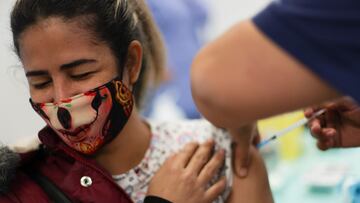 A woman receives a dose of Pfizer/BioNTech coronavirus disease (COVID-19) vaccine during a vaccination campaign inside the University of Santiago, Chile June 30, 2021. REUTERS/Ivan Alvarado