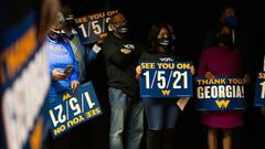 Family and supporters hold runoff signs as Democratic U.S. Senate candidate Rev. Raphael Warnock speaks during an Election Night event in Atlanta, Georgia, November 3, 2020. Jessica McGowan/Pool via REUTERS