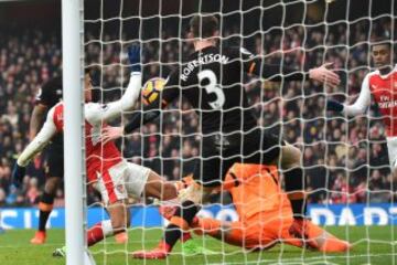 Arsenal's Chilean striker Alexis Sanchez (L) scores the opening goal of the English Premier League football match between Arsenal and Hull City at the Emirates Stadium in London on February 11, 2017. / AFP PHOTO / Glyn KIRK / RESTRICTED TO EDITORIAL USE. No use with unauthorized audio, video, data, fixture lists, club/league logos or 'live' services. Online in-match use limited to 75 images, no video emulation. No use in betting, games or single club/league/player publications. /