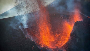 In this handout photograph taken and released by the Spanish Military Emergency Unit (UME) on November 28, 2021 the Cumbre Vieja volcano spews lava, ash and smoke on the Canary island of La Palma. - It has been more than two months since Cumbre Vieja bega