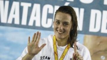 Mireia Belmonte señala el seis, que es el número de oros que se lleva de los Campeonatos de España.