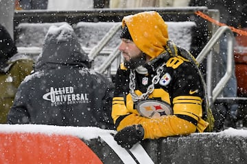 Bajo la nieve, un fan de los Pittsburgh Steelers observa el partido durante el cuarto cuarto n Cleveland.