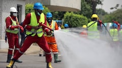 Fire service crews decontaminate a street in Abuja. 