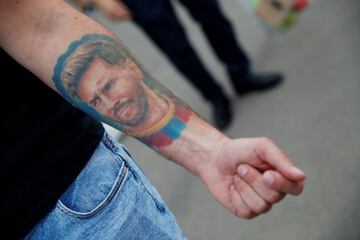 Amanece en Barcelona y los seguidores continúan con el mismo guión, acudir al Camp Nou para rendir homenaje y pedir explicaciones tras la salida de Messi. Un aficionado muestra un tatuaje del argentino.