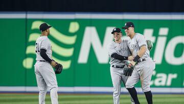 TORONTO, ON - SEPTEMBER 27: Aaron Judge #99 of the New York Yankees celebrates alongside Harrison Bader #22 and Aaron Hicks #31 in the outfield after the last out of their MLB game against the Toronto Blue Jays, as they clinch the AL East, at Rogers Centre on September 27, 2022 in Toronto, Canada. Cole Burston/Getty Images/AFP
