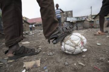 El fútbol es un deporte global, que se puede practicar casi en cualquier parte y casi con cualquier balón. Así piensan miles de niños africanos que disfrutan del balonpié con lo poco que tienen, como estos chicos de Nairobi (Kenya). 