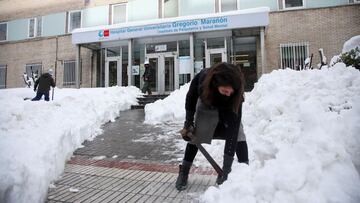 MADRID, 10/01/2021.- Varios voluntarios despejan con palas el acceso a una de las entradas del Hospital Gregorio Marañon de Madrid, cubierto de una gruesa capa de nieve tras el paso de la borrasca Filomena. EFE/David Fernández