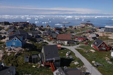 Casas en pie mientras icebergs flotan a la deriva en la bahía de Disko el 15 de julio de 2024 en Ilulissat, Groenlandia. Las autoridades groenlandesas buscan mejorar la infraestructura turística del territorio. Ilulissat es uno de los principales destinos turísticos de Groenlandia.